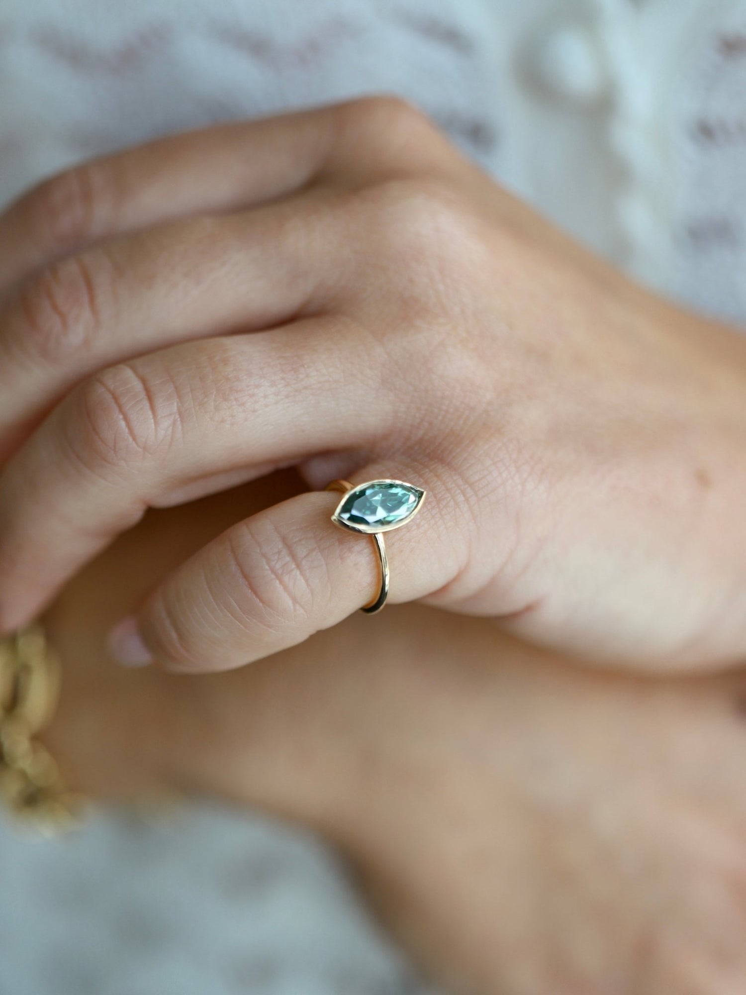 Unique marquise cut blue-green moissanite ring in bezel setting