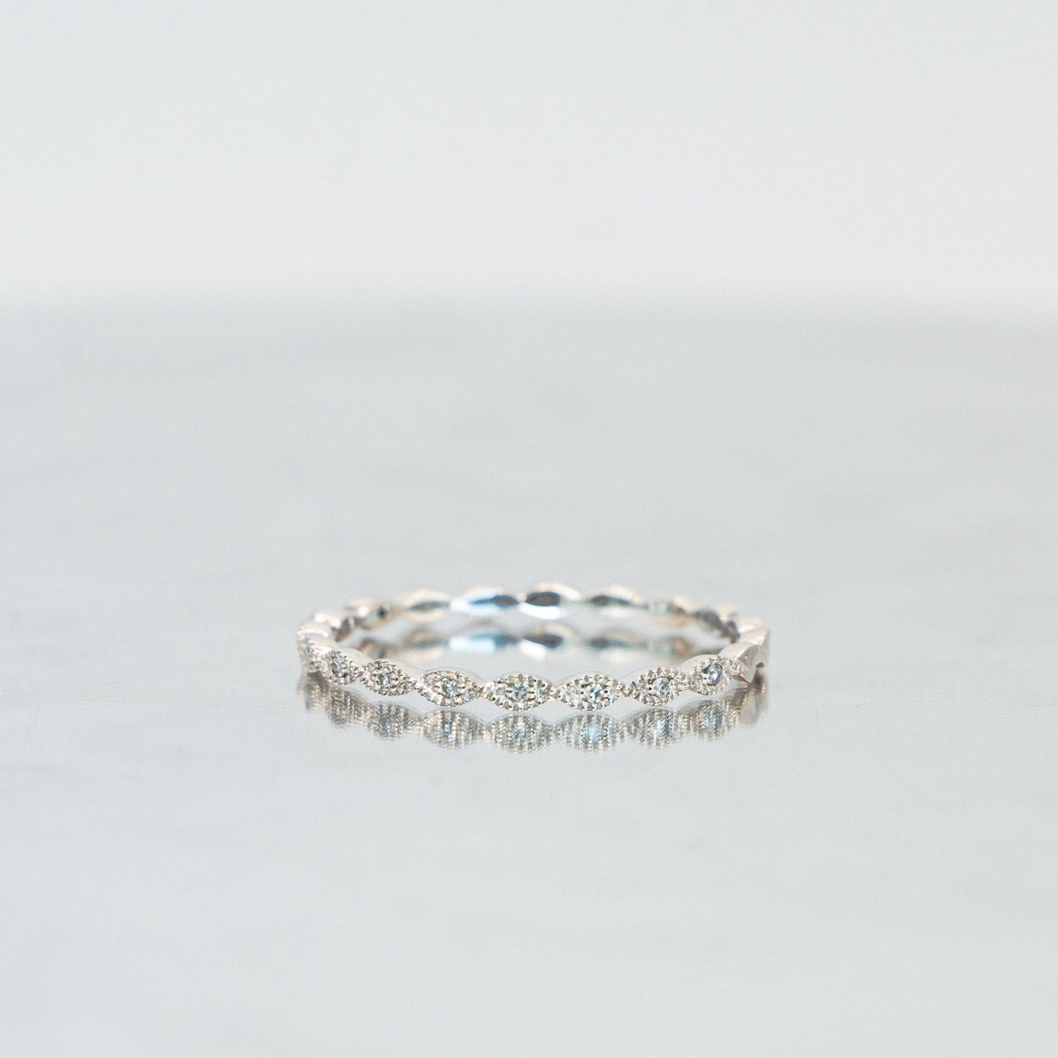 A delicate white gold eternity band with elliptical diamond settings
