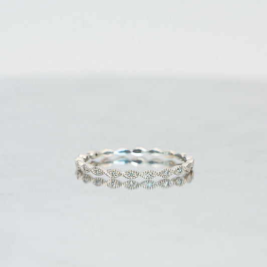 A delicate white gold eternity band with elliptical diamond settings